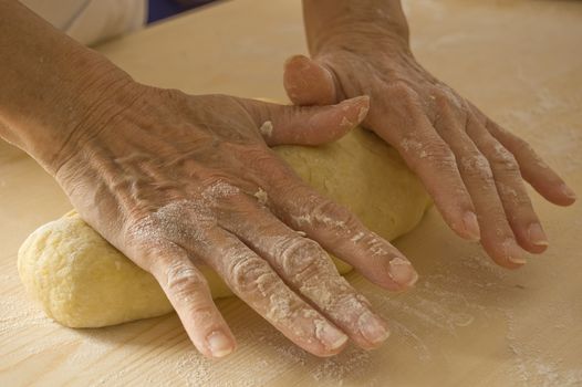 Woman hands work into dough
