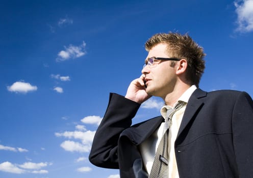 A businessman dressed in a smart suit standing on grass