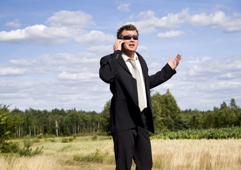 A businessman dressed in a smart suit standing on grass