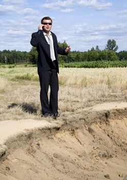 A businessman dressed in a smart suit standing on grass