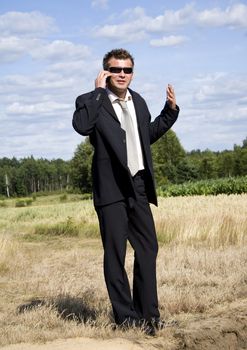 A businessman dressed in a smart suit standing on grass