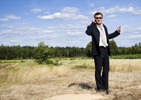 A businessman dressed in a smart suit standing on grass