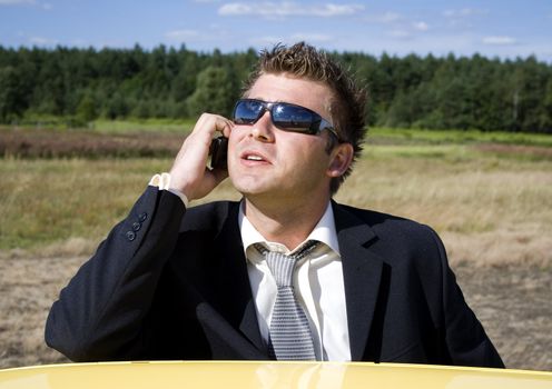 A businessman dressed in a smart suit standing on grass