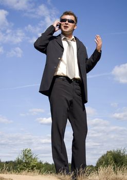 A businessman dressed in a smart suit standing on grass