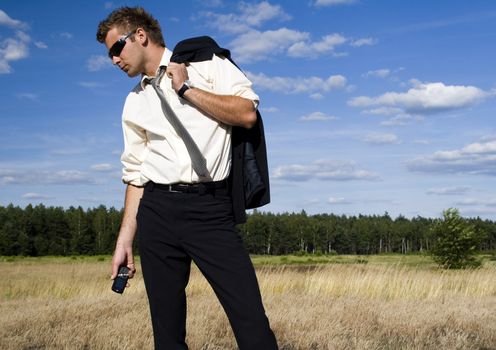 A businessman dressed in a smart suit standing on grass