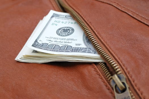 Lot of dollars in a pocket of leather jacket.