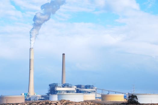 Smokestacks of power station on sky background