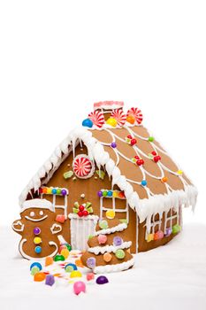 Gingerbread house, man and Christmas tree covered with snow and colorful candy on a winter landscape, isolated.