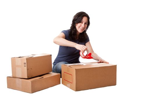 Attractive happy beautiful woman putting tape on cardboard moving storage boxes parcels preparing for mail, isolated.