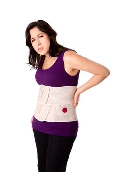 Woman in pain from back injury wearing an orthopedic body brace corset, isolated.