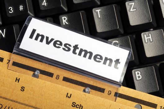 investment word on business folder showing financial success concept