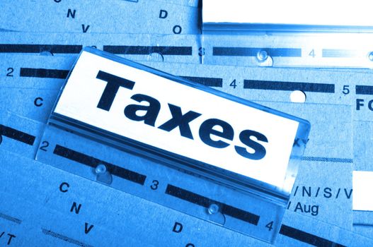 tax or taxes concept with word on business folder index