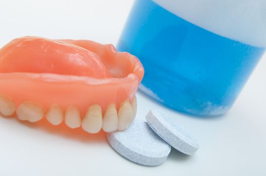 Denture with cleaning tablets and water glass