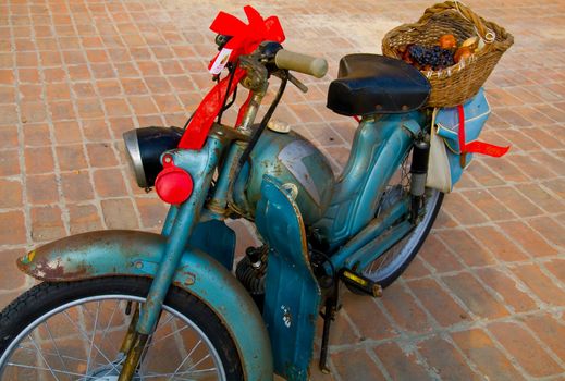 Old moped with a basket of fruit back