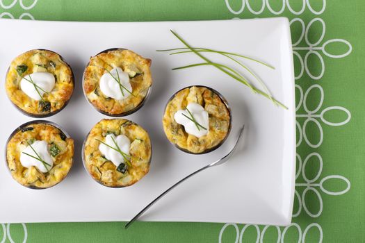 Five quiche appetizers with sour cream and chives.