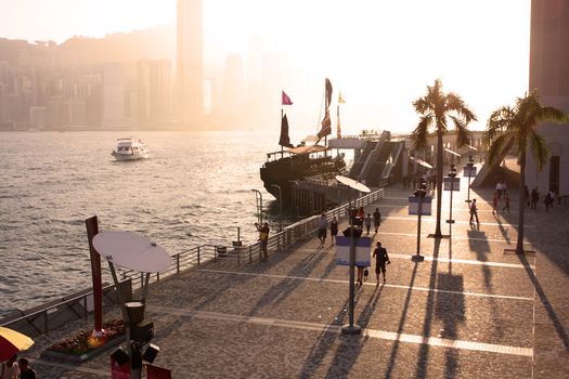 hong kong sunset and the people moving ob the plaza