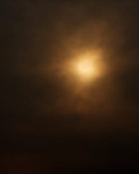 Dark background formed by the sun behind a layer of clouds