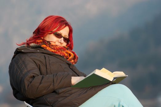 Woman reading a book outdoors