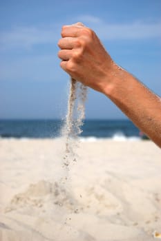 Concept photo of sand falling from the man's hand. 