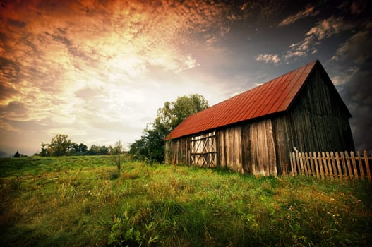 Old wooden bar with red roof over the dramatic sunset. Zalew Zegrzynski, Poland