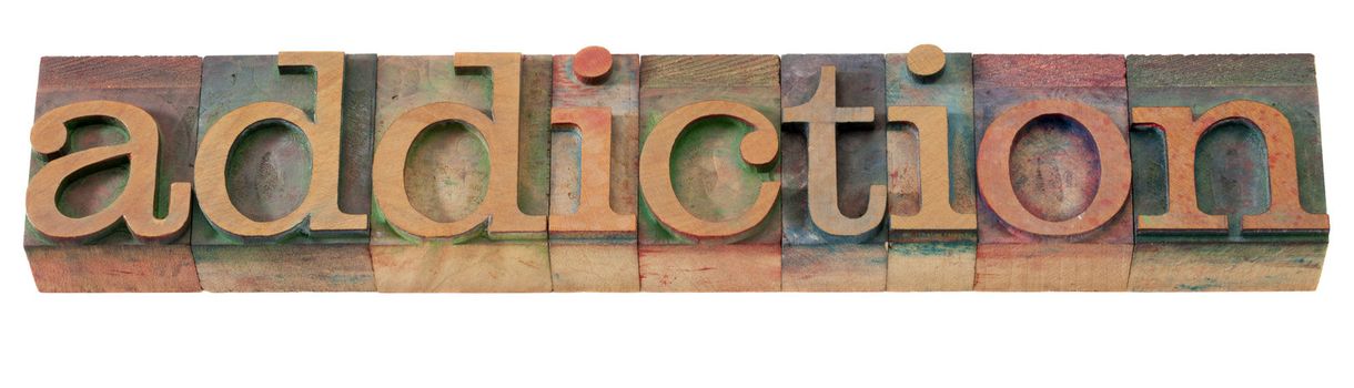addiction word  in vintage wooden letterpress printing blocks, stained by color inks, isolated on white