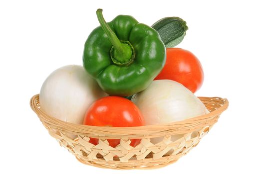 Basket with green pepper, tomatoes, onions and zucchini isolated on white background
