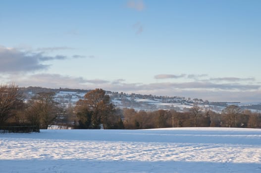 Countryside landscape with field covered in snow.