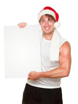 Fitness man holding sign wearing christmas santa hat. Fit male fitness model isolated on white background.