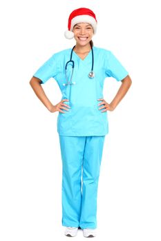 nurse or young doctor wearing christmas santa hat smiling happy standing isolated on white background in full body wearing scrubs. Beautiful multicultural Asian Caucasian female medical professional.