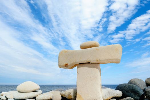 Small pebble on a large horizontal stone on seacoast