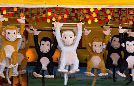 Prize monkeys at a game of chance on a seaside boardwalk.