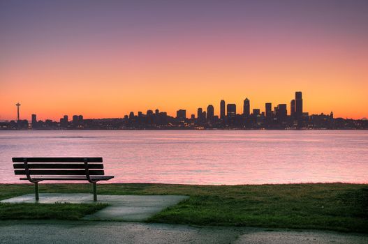 Sunrise over Emerald city Seattle, park bench in the foreground