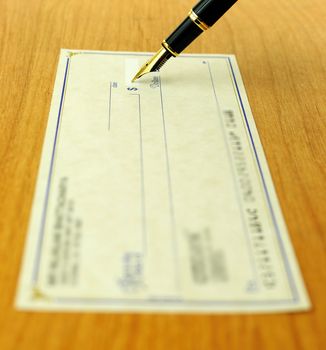 business transaction using a check, shallow focus on the pen tip