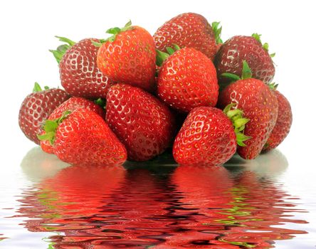 Delicious bunch of ripe strawberries with reflection over water