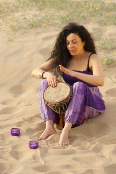 Woman outdoors enjoying the sunshine and playing her djembe