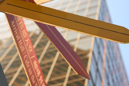 Concept image of a signpost against a modern glass office building 