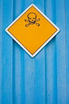 Skull and crossbones warning sign on blue background white with lots of copyspace for your message.