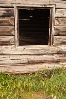 Historic log house, wall with glassless window frame.