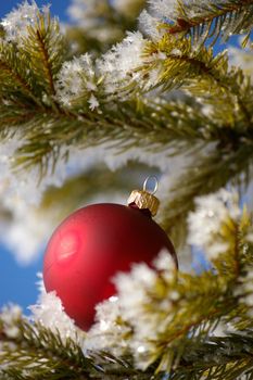 red bauble christmas ball ornament outside in a snowy winter scene