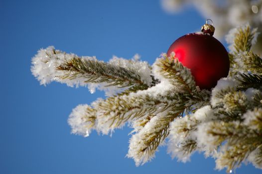 red bauble christmas ball ornament outside in a snowy winter scene