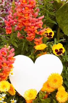 Garden flowers with white, heart shaped copyspace for your message of love.