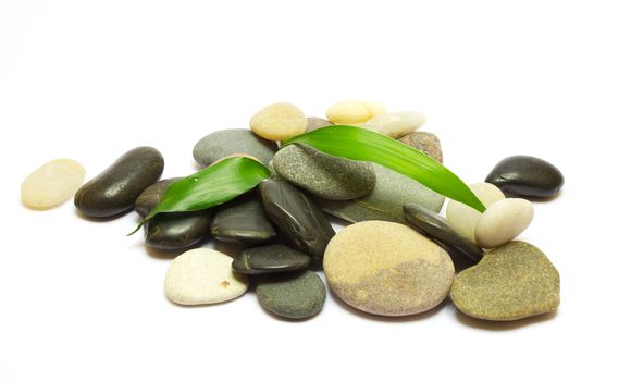 Pile of stones and bamboo leafs isolated on white