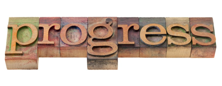 progress - word in vintage wooden letterpress printing blocks, stained by color inks, isolated on white