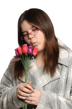 A brunette teen is holding multicolored wooden roses, isolated against a white background.
