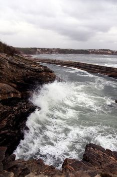 View of a furious wave hitting the cliffs on the coastline of Alentejo, Portugal.