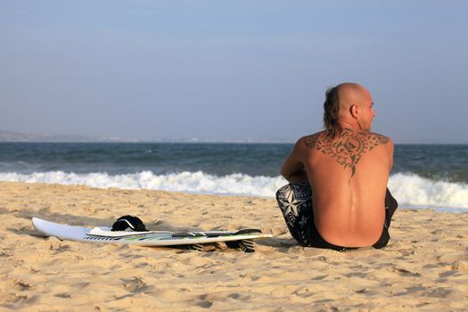 Kitesurfer with surferboard pending a wind