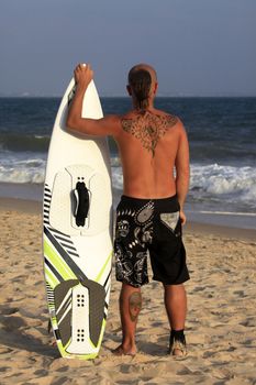 Kitesurfer with surferboard pending a wind