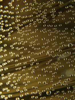 Many small bubbles in water, golden background