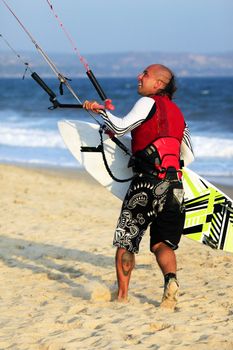 Kitesurfer with surferboard on the beach