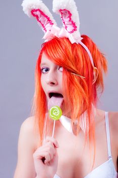 woman easter bunny on gray background with orange hair